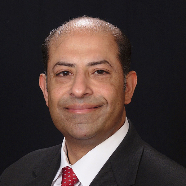 A professional headshot of Kaustuv Datta, a loan officer at Kwik Mortgage, wearing a business suit and smiling confidently